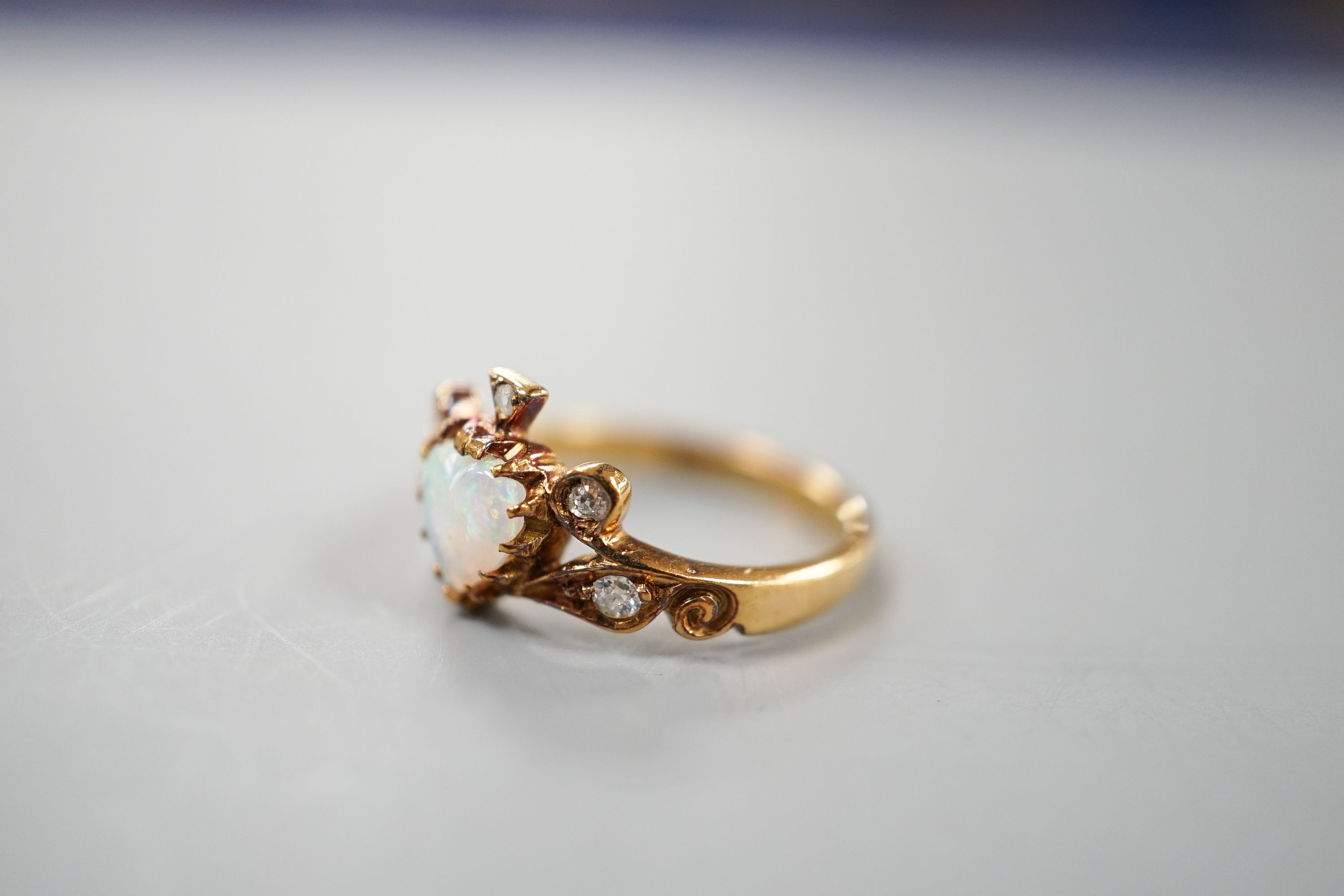 A late Victorian 18ct gold, heart shaped white opal and five stone diamond chip set dress ring, size I, gross weight 2.6 grams.